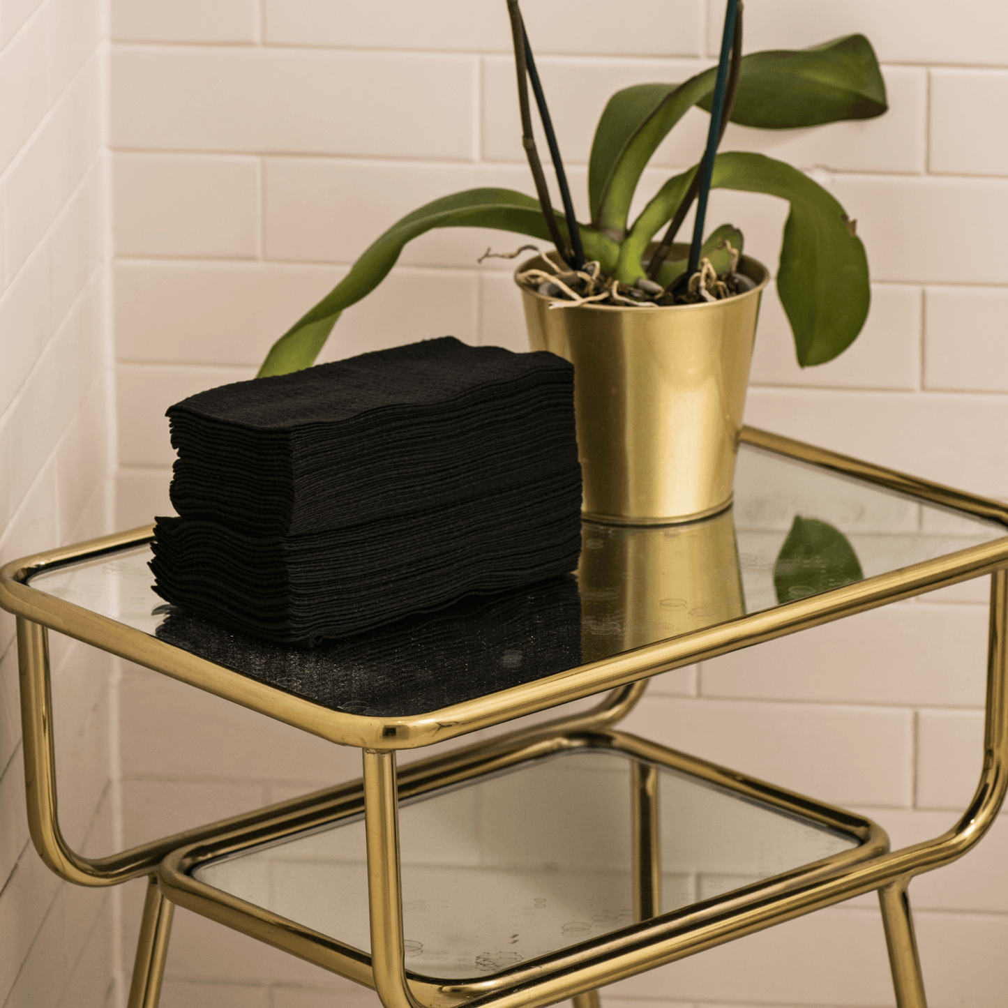 Image of a stack of View details for Luxury Hand Towels Luxury Hand Towels in black, neatly organised in a salon. The towels feature a textured waffle weave and soft material, ready for use. The disposable and biodegradable qualities of the towels are hig