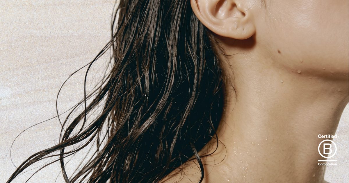 Close-up of a person's neck and wet hair against a neutral background