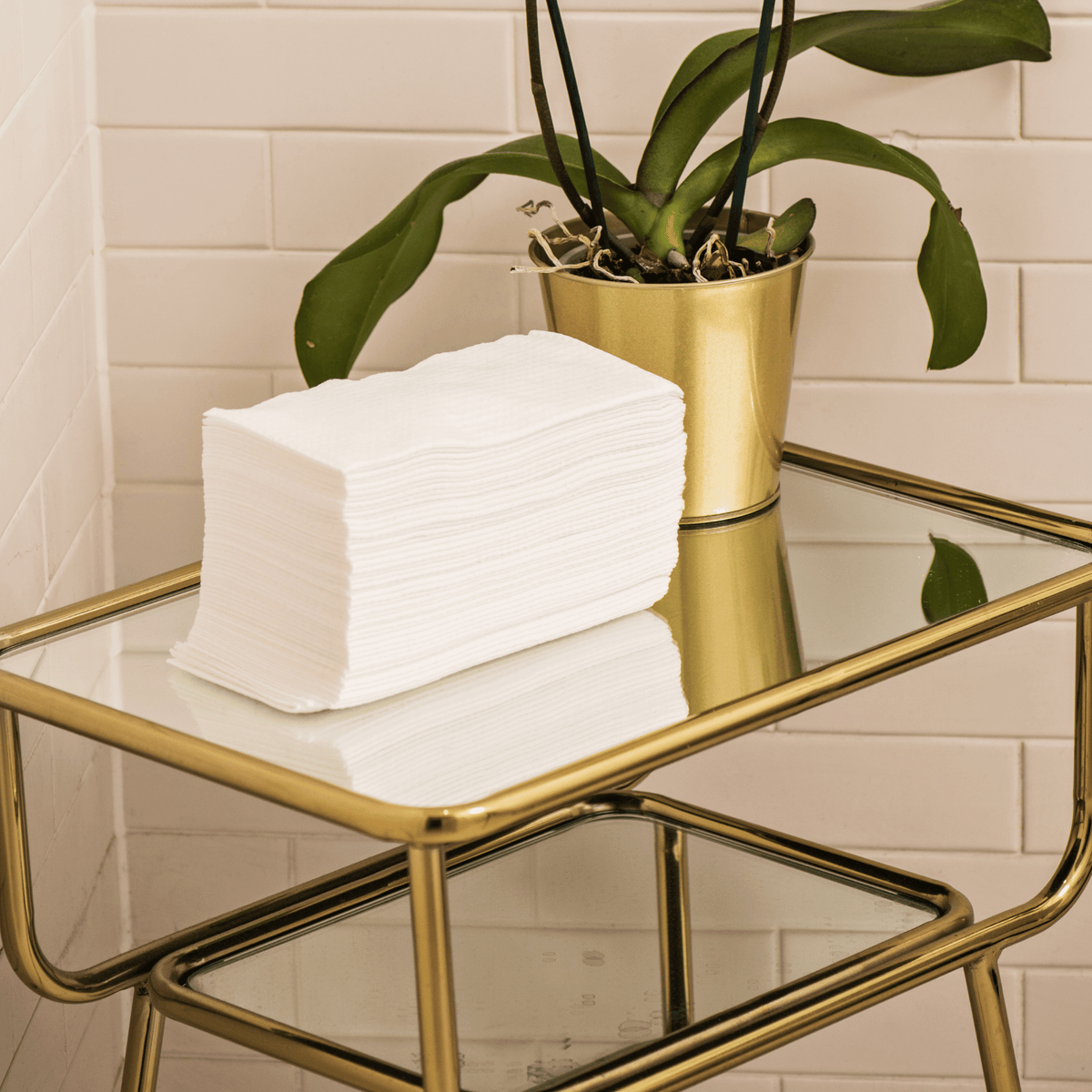 Image of a stack of Scrummi View details for Luxury Hand Towels Luxury Hand Towels in white, neatly arranged in a salon. The towels, with their textured waffle weave, are displayed to highlight their soft, absorbent material. The disposable and biodegrada
